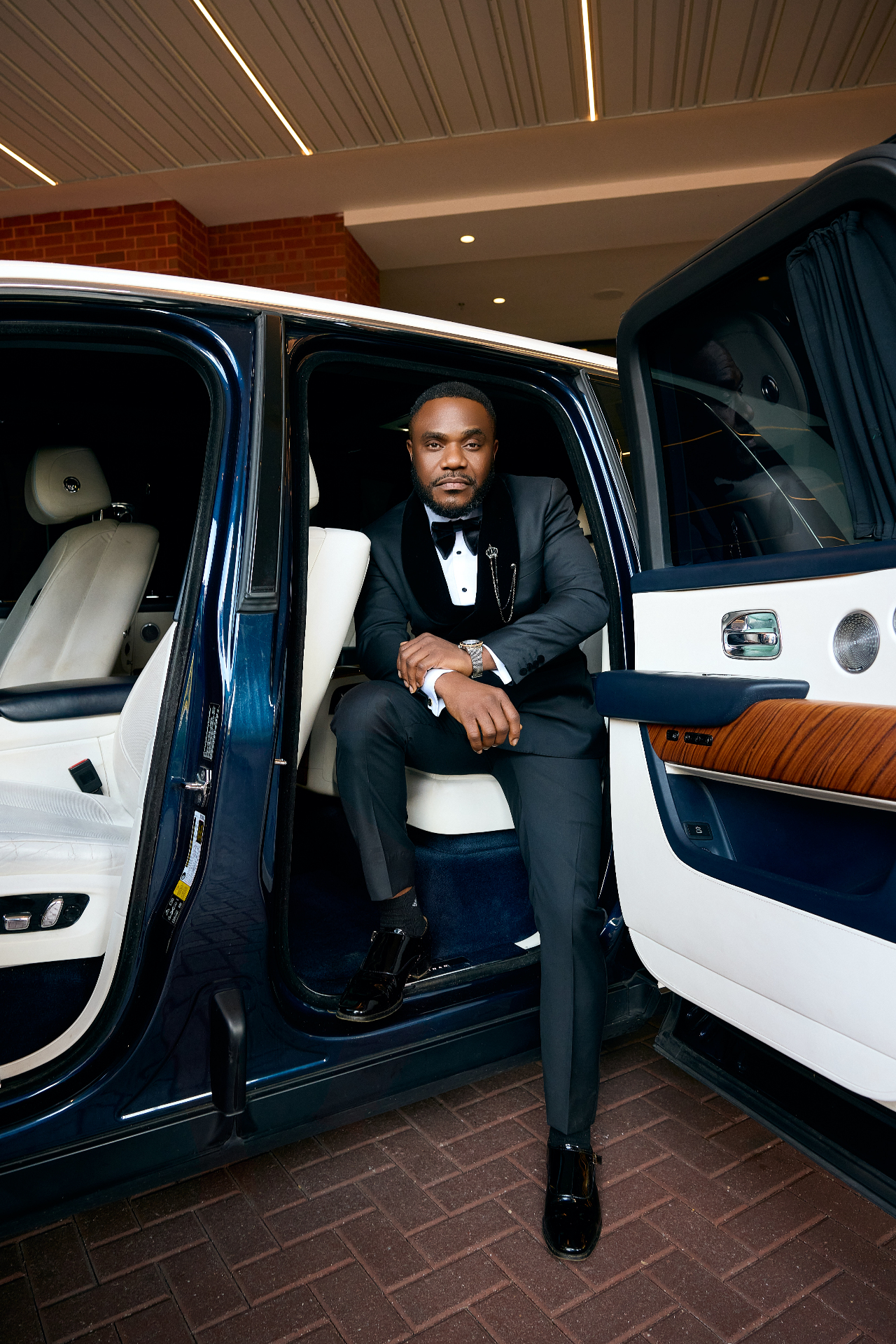 Arinze seated in the open car doorway